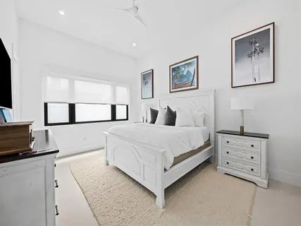 a bedroom with a bed and a flat tv screen on the dresser