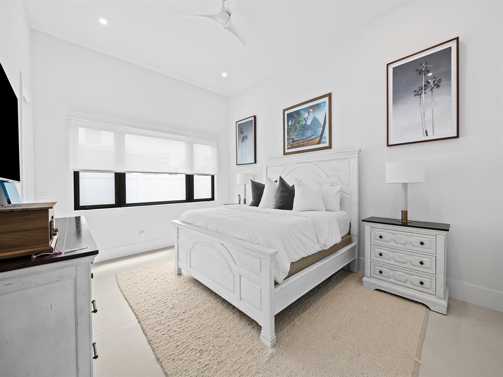 2420 Northeast 48th Street Lighthouse Point, FL 33064 - Photo 34 of 51 a bedroom with a bed and a flat tv screen on the dresser