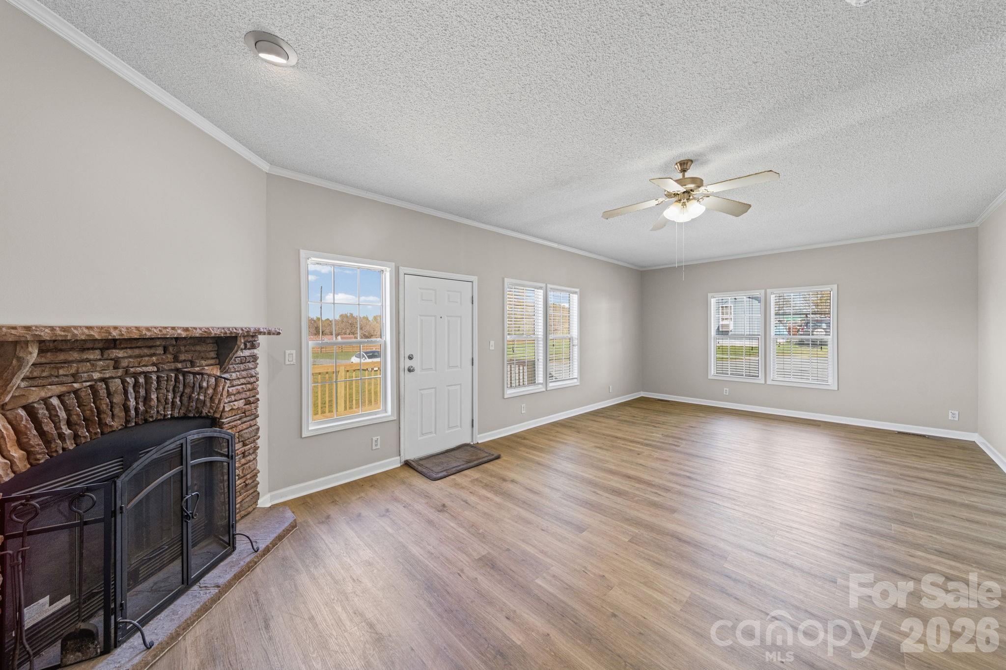 3010 Old Monroe Marshville Road Wingate, NC 28174 - Photo 12 of 44 a view of an empty room with a kitchen and wooden floor