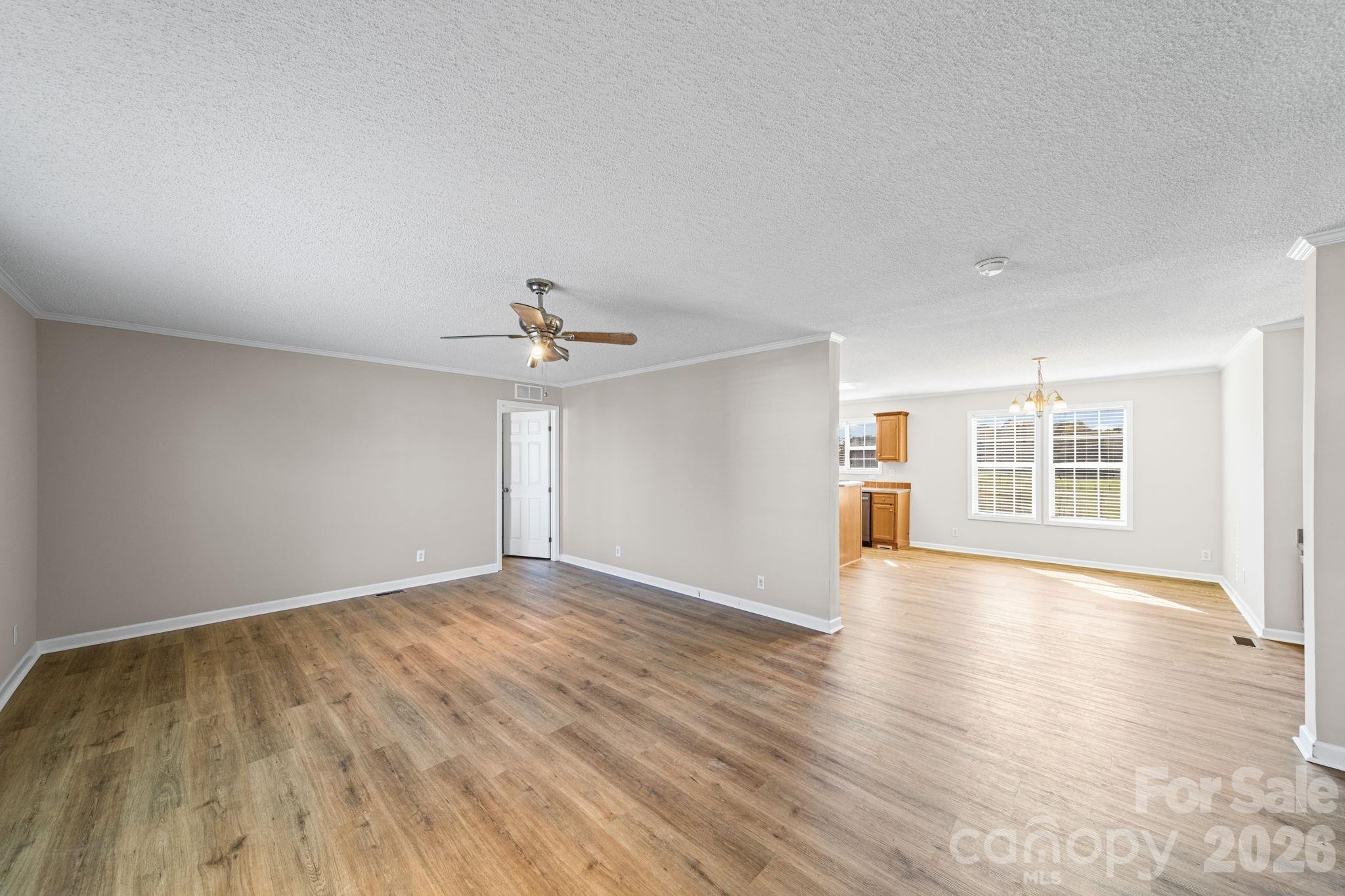 3010 Old Monroe Marshville Road Wingate, NC 28174 - Photo 13 of 44 an empty room with wooden floor ceiling fan and windows