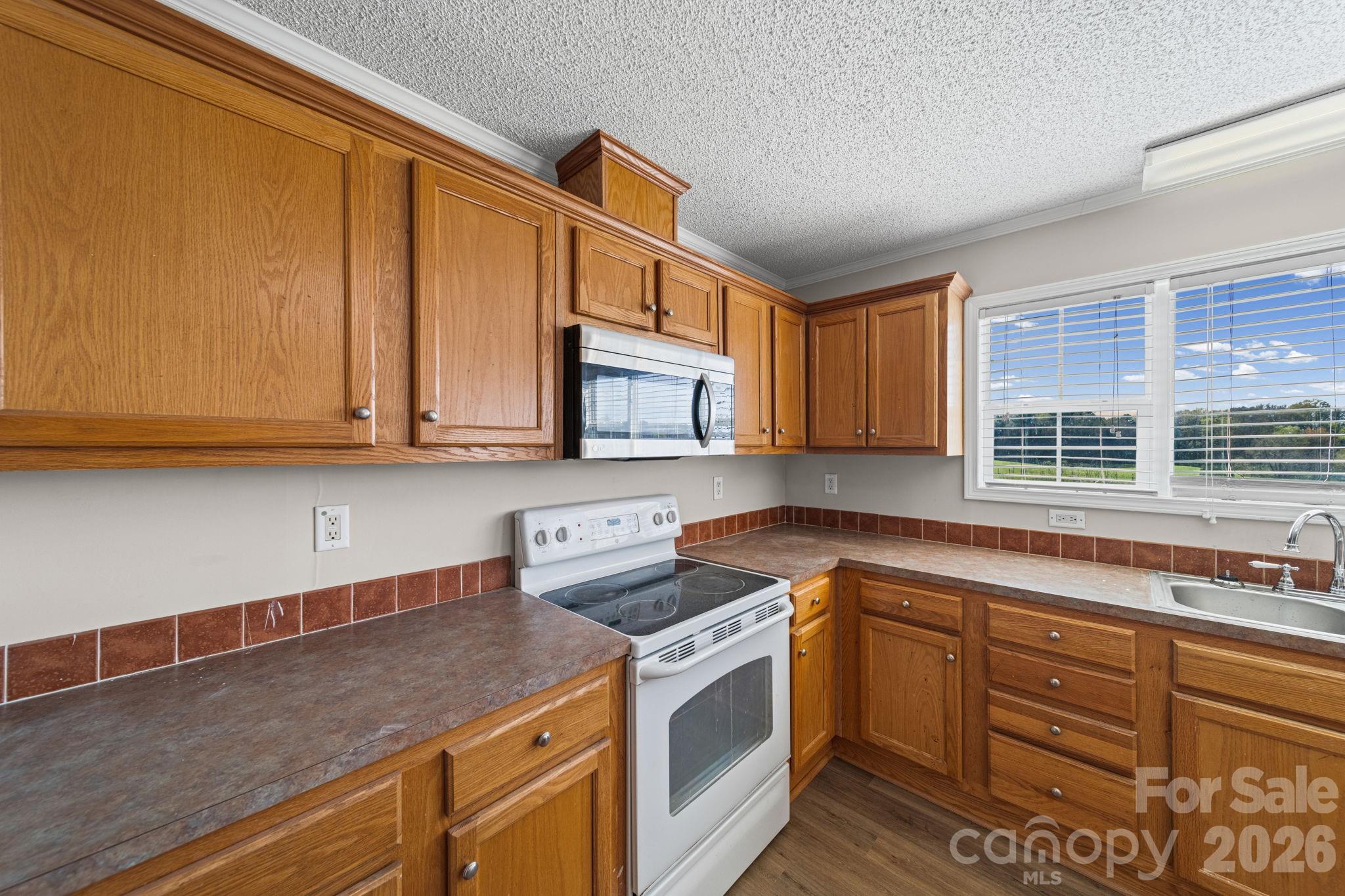 3010 Old Monroe Marshville Road Wingate, NC 28174 - Photo 17 of 44 a kitchen with stainless steel appliances granite countertop a sink stove and cabinets