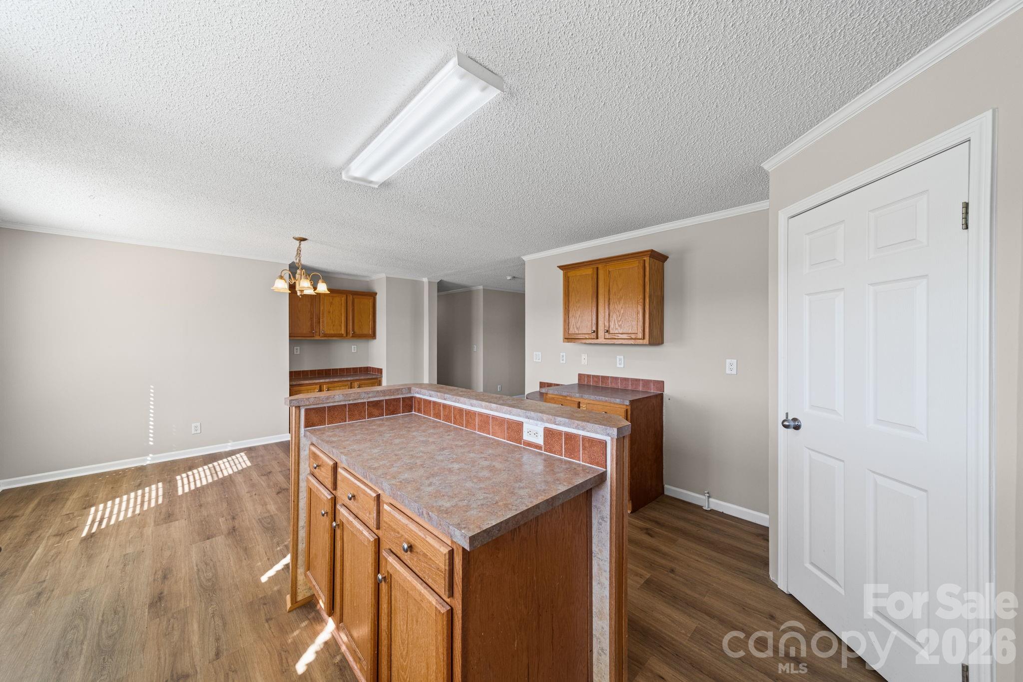 3010 Old Monroe Marshville Road Wingate, NC 28174 - Photo 18 of 44 a view of kitchen island a sink wooden floor and a refrigerator