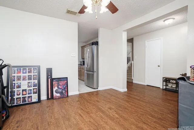 a view of a livingroom with wooden floor and furniture