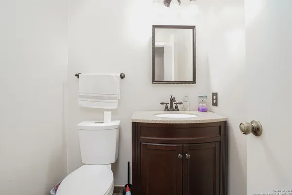 a bathroom with a toilet sink and mirror