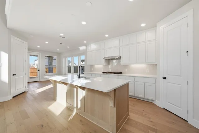 a kitchen with kitchen island a sink and a stove top oven