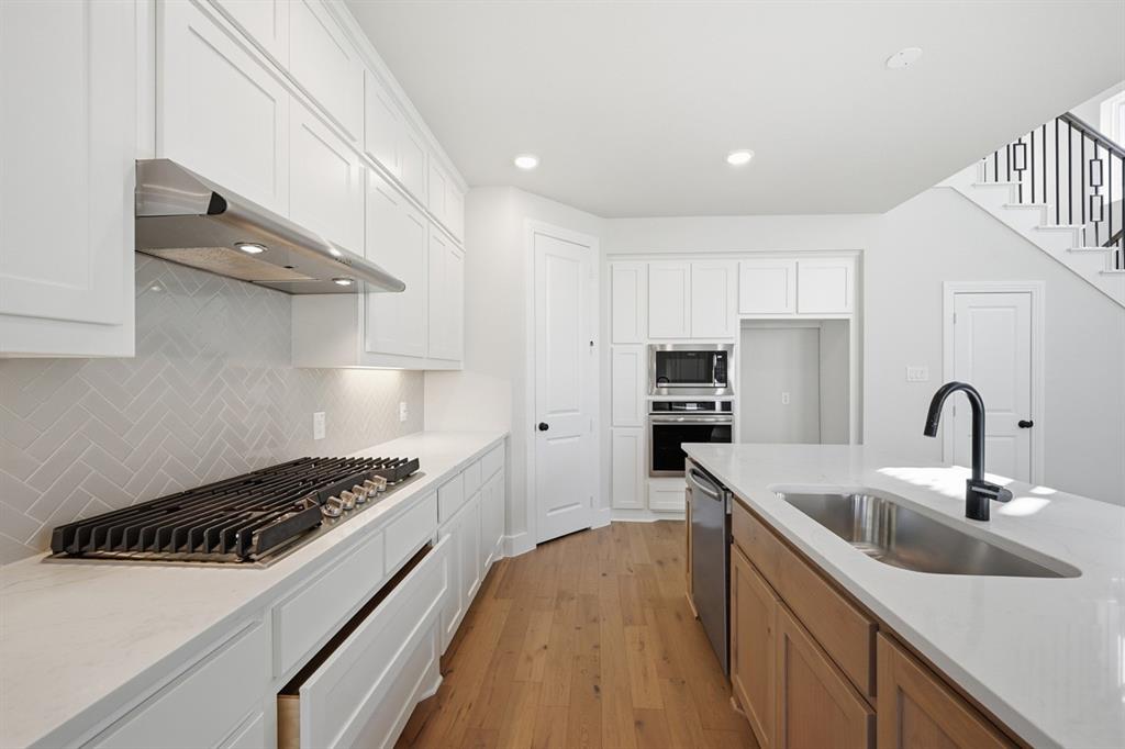 4409 Script Street Prosper, TX 75078 - Photo 6 of 24 a kitchen with kitchen island a sink stainless steel appliances and cabinets