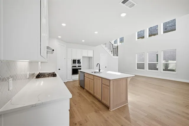 a kitchen with stove a sink and cabinets