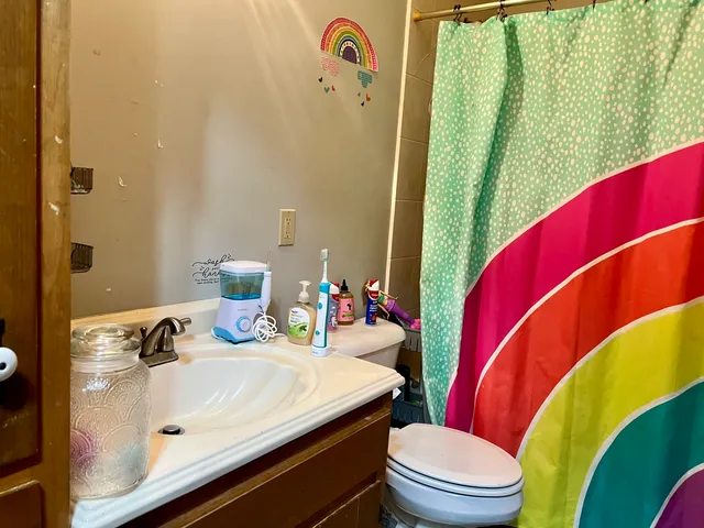 a bathroom with a sink mirror vanity and toilet