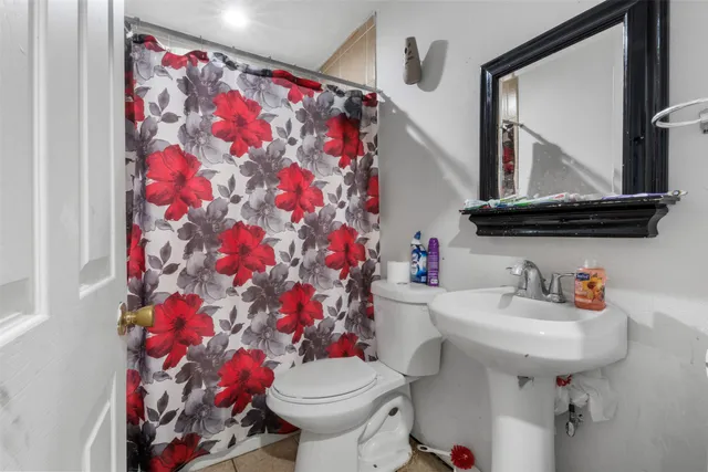 a bathroom with a sink mirror and toilet