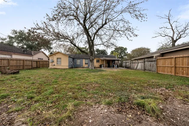 a view of a house with backyard and trees