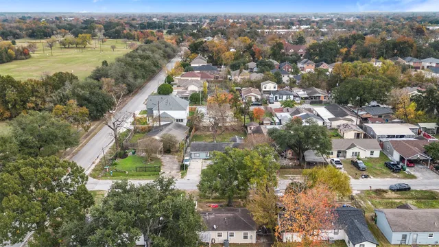 an aerial view of city and lake with trees