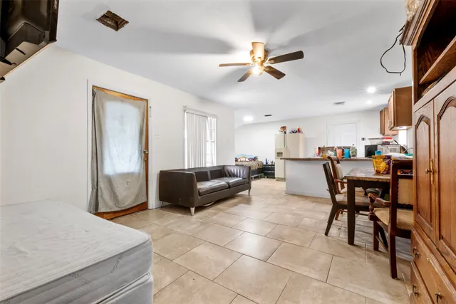 a living room with a couch and a dining table with wooden floor