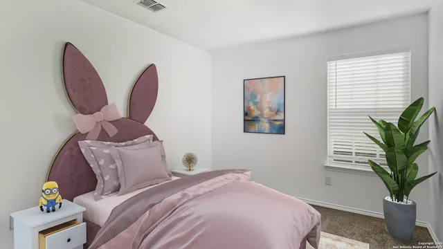 a bedroom with a bed and a potted plant