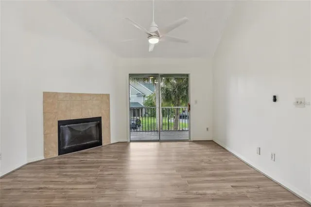 a view of empty room with wooden floor and fireplace