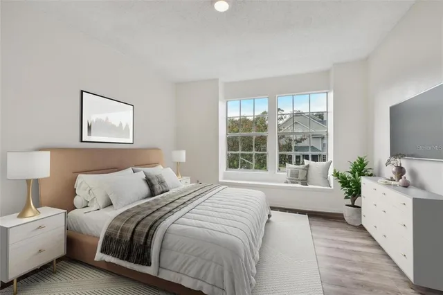 a bedroom with a large bed and a flat screen tv