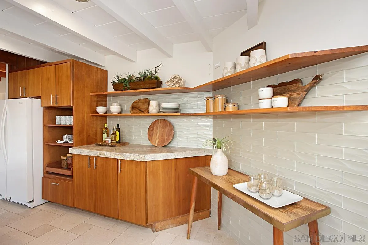 6243 Dowling Drive La Jolla, CA 92037 - Photo 12 of 28 a kitchen with a refrigerator a stove top oven a sink and dishwasher
