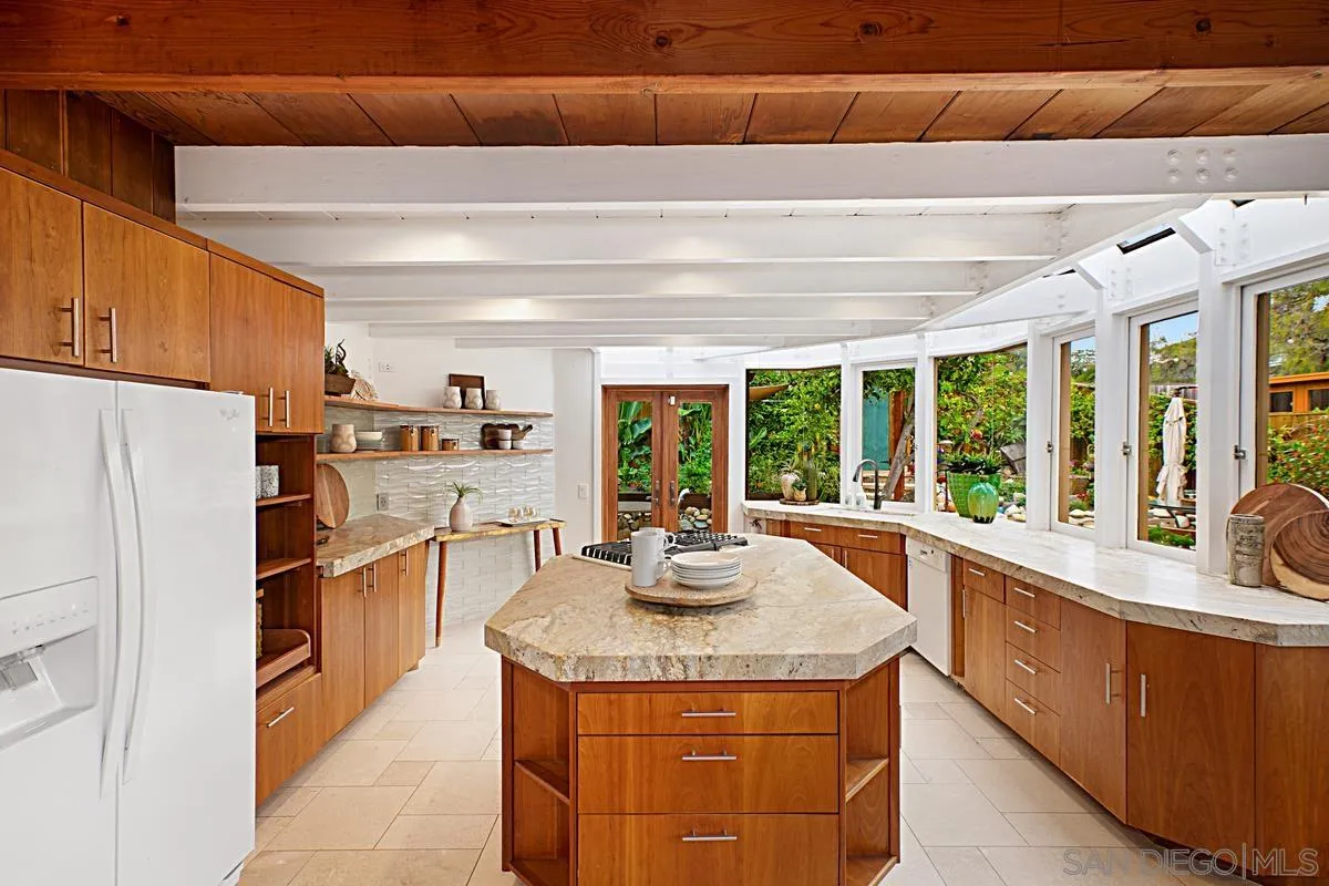 6243 Dowling Drive La Jolla, CA 92037 - Photo 9 of 28 a kitchen with granite countertop a sink and a refrigerator
