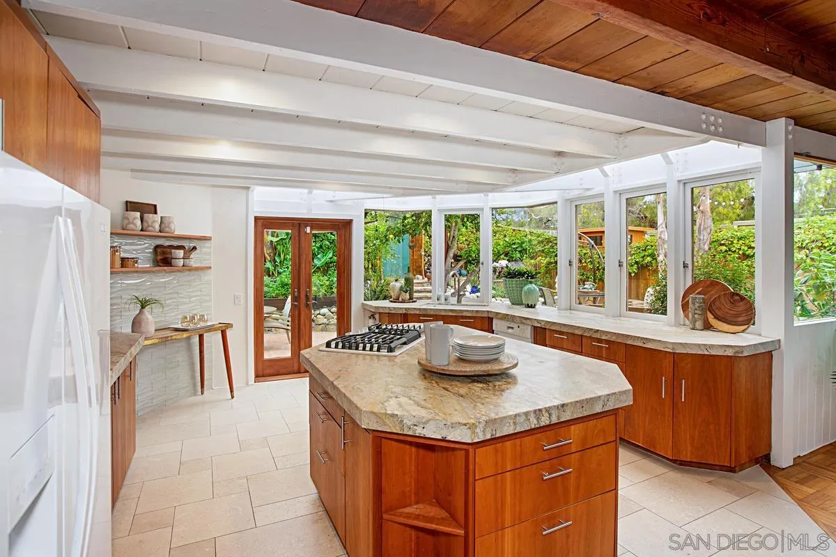 6243 Dowling Drive La Jolla, CA 92037 - Photo 10 of 28 a kitchen with a stove a sink and a dining table