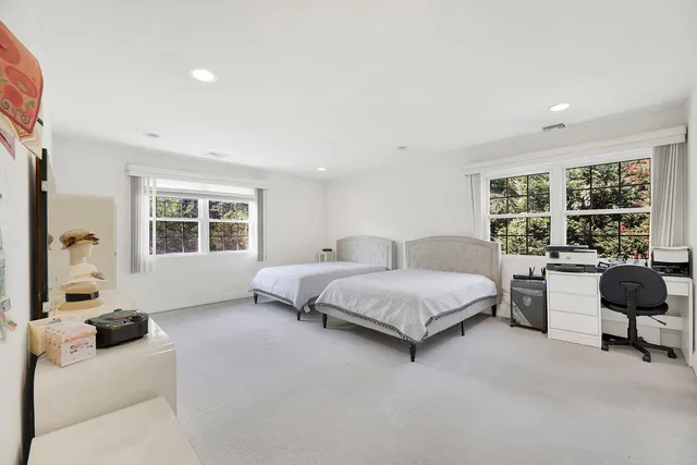 a spacious bedroom with a bed a couch and a window