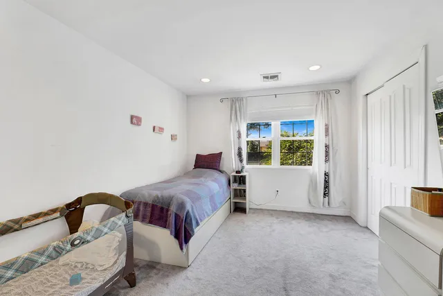 a spacious bedroom with a bed and a large window