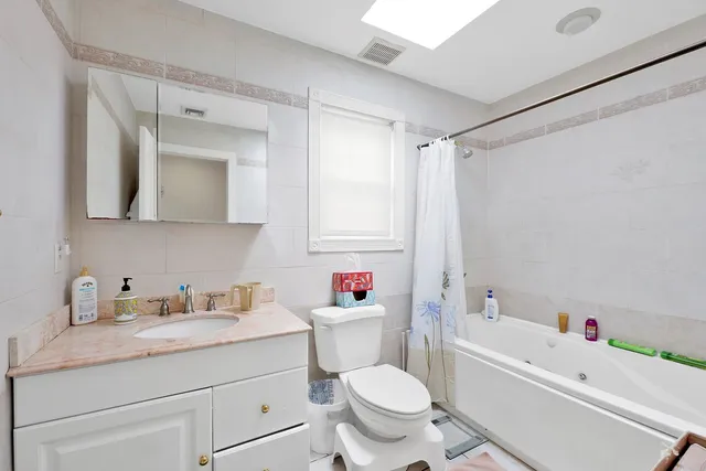 a bathroom with a sink toilet vanity and bathtub