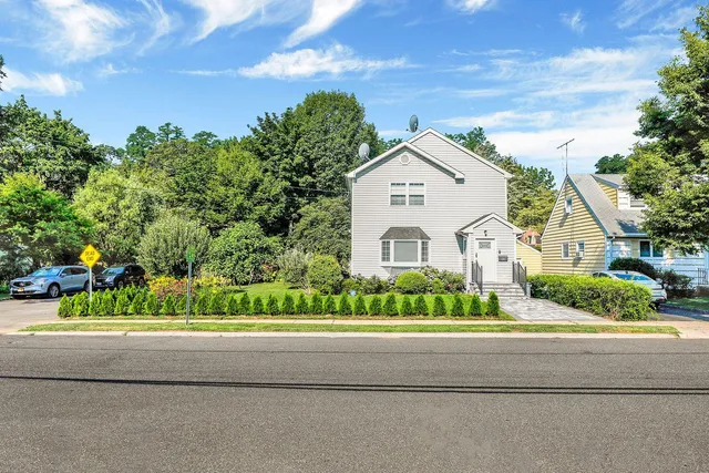 a front view of a house with a garden and plants