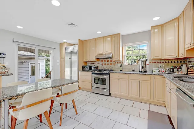 a kitchen with stainless steel appliances granite countertop a stove a sink and a refrigerator