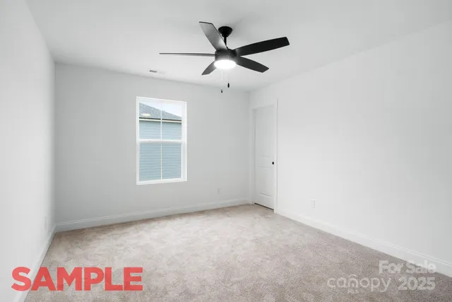 an empty room with ceiling fan and window