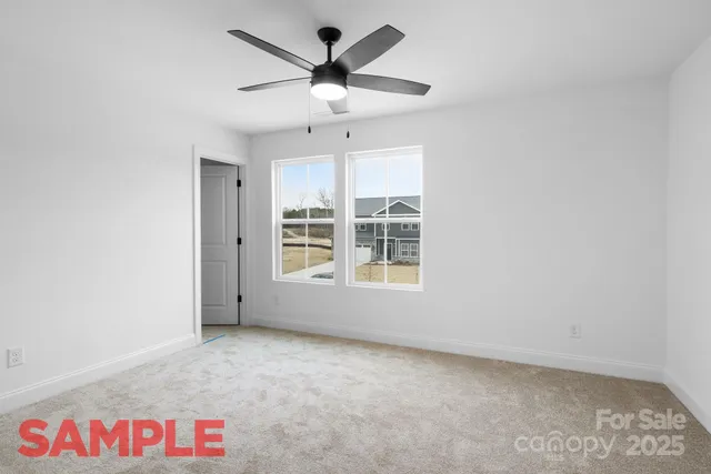 an empty room with a ceiling fan and window