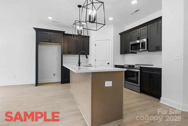 a kitchen with stainless steel appliances a sink stove and microwave