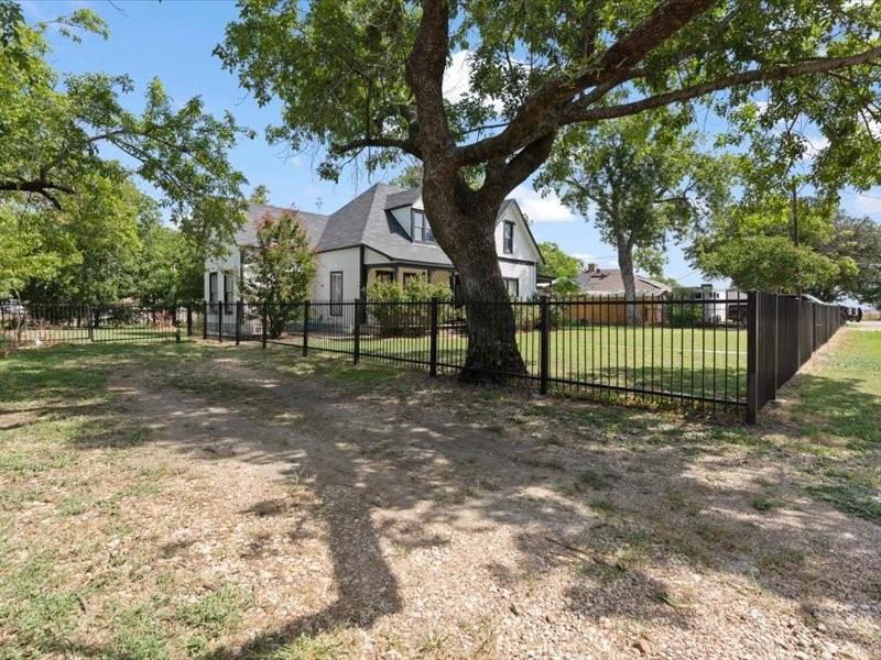 809 East Adams Street Itasca, TX 76055 - Photo 2 of 31 a view of a yard in front of a house with large trees
