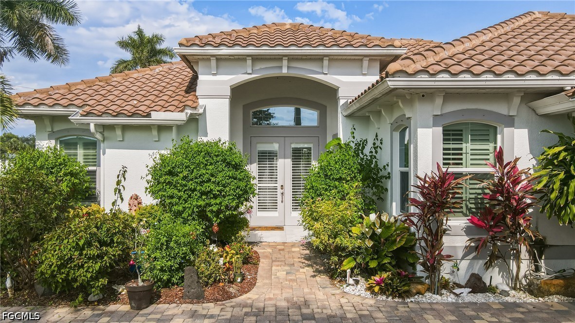 1700 43rd Terrace Southwest Naples, FL 34116 - Photo 2 of 38 a front view of a house with a garden