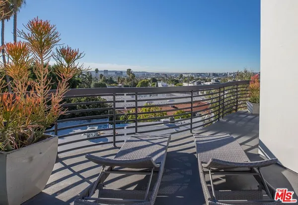 a terrace with outdoor seating and city view