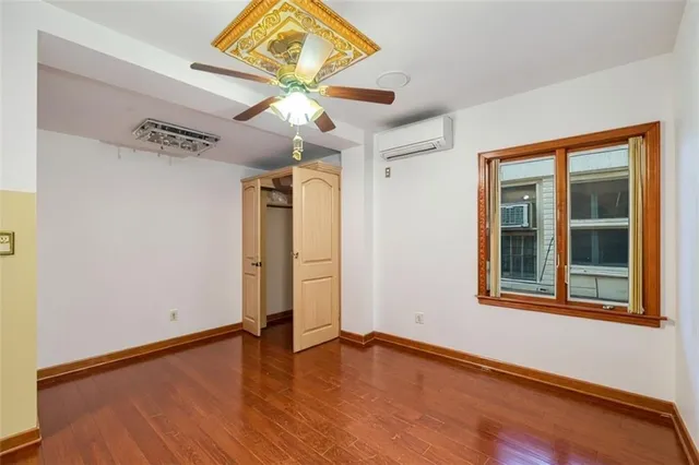 an empty room with wooden floor and closet area