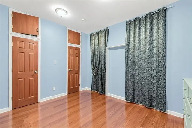 an empty room with wooden floor and a window
