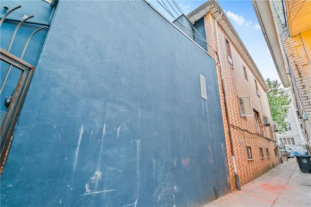 a backyard of a house with a large tree and wooden fence