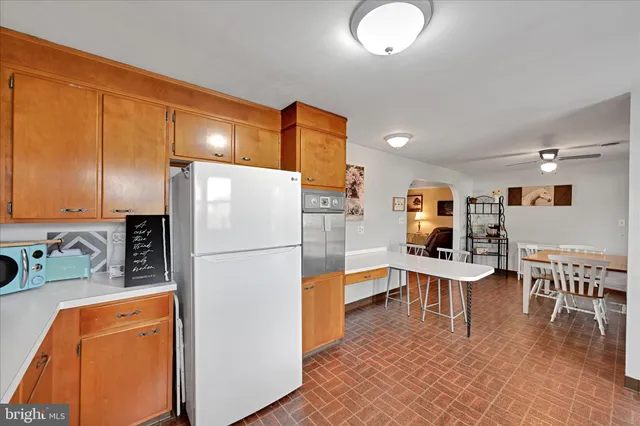 a kitchen with stainless steel appliances granite countertop a refrigerator a sink a stove and white cabinets