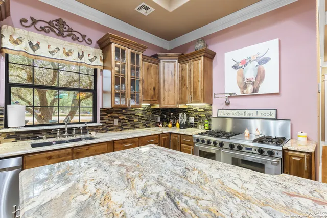 a kitchen with stainless steel appliances granite countertop a stove and a sink
