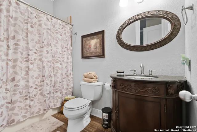 a bathroom with a granite countertop toilet and a sink