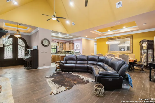 a living room with furniture a clock and a ceiling fan