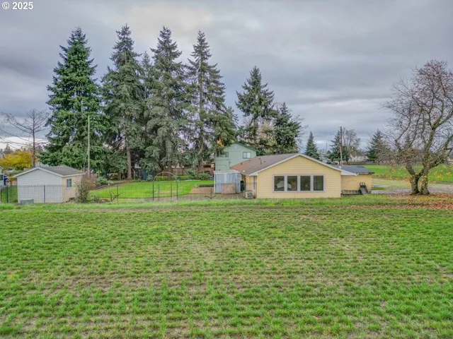 a front view of a house with a yard and trees
