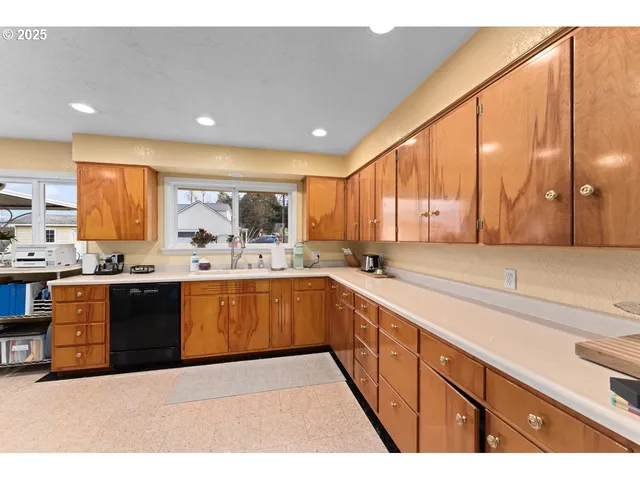 a large kitchen with stainless steel appliances kitchen island granite countertop a sink and cabinets