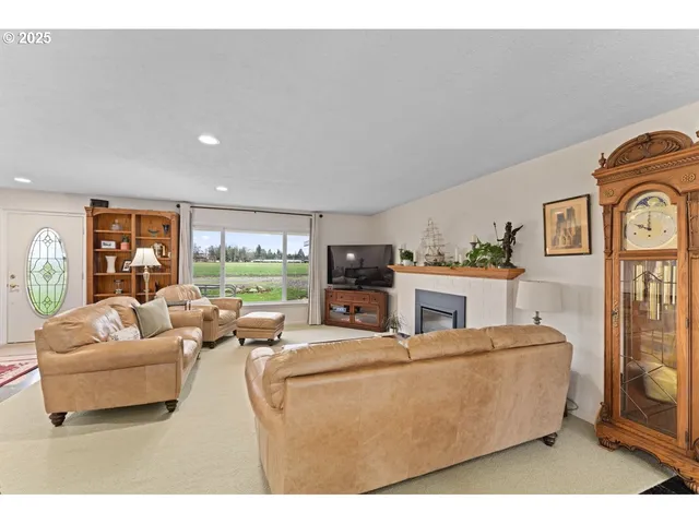 a living room with furniture a flat screen tv and a large window