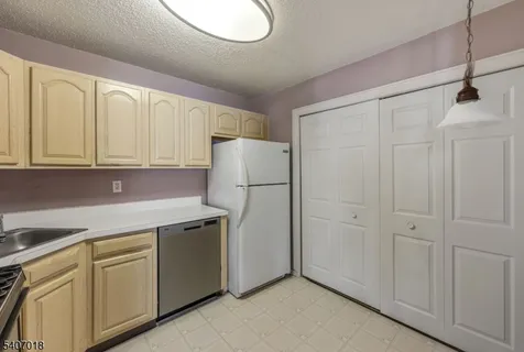 a kitchen with cabinets and white stainless steel appliances