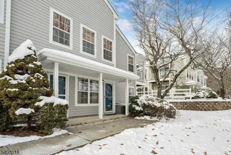 a view of a house with a yard covered in snow
