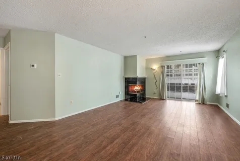 a view of a livingroom with wooden floor and furniture