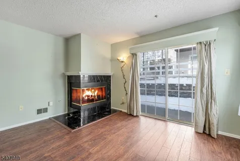 a living room with hardwood floor and a flat screen tv