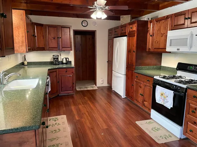 a kitchen with stainless steel appliances granite countertop a refrigerator a stove and a wooden floors