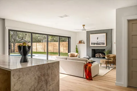 a living room with fireplace furniture and a large window