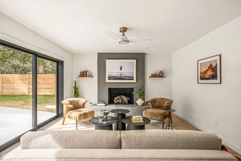 a living room with furniture large window and a fireplace